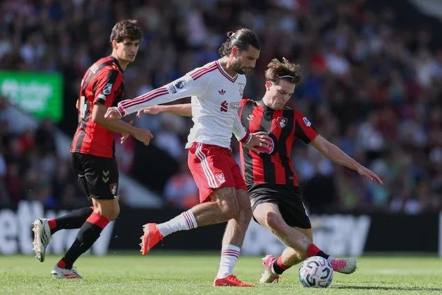 Pemain Liverpool Dominik Szoboszlai berduel dengan pemain Bournemouth Alex Scott dalam pertandingan Premier League, Minggu (20/9/2026). (foto: AP Photo/Ian Walton)